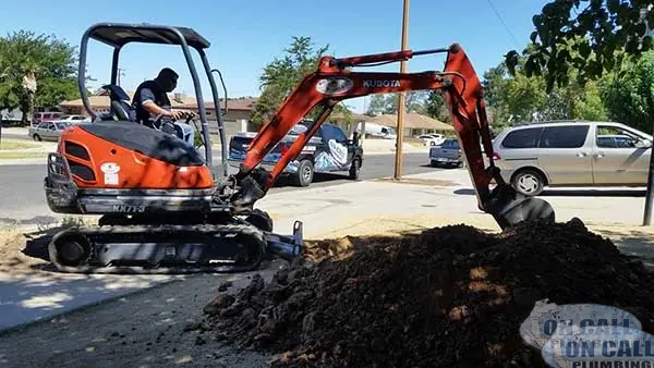 Mini excavator digging out a sewer line