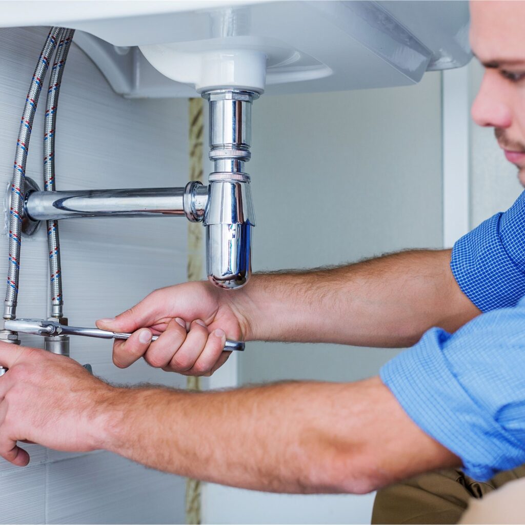 plumber fixing under bathroom sink