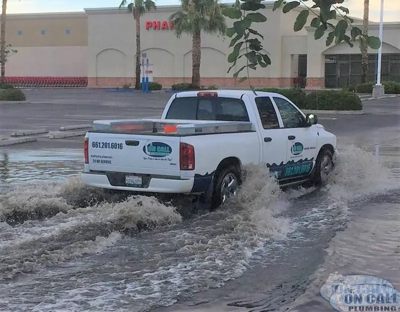 On Call Plumbing truck driving through flood water to an emergency call